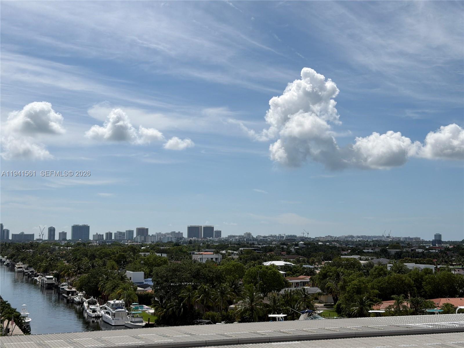 An elevated view shows a canal with docked boats alongside a lush residential neighborhood — 13499 Biscayne Blvd # 710, North Miami FL 33181, NORTH MIAMI, FL