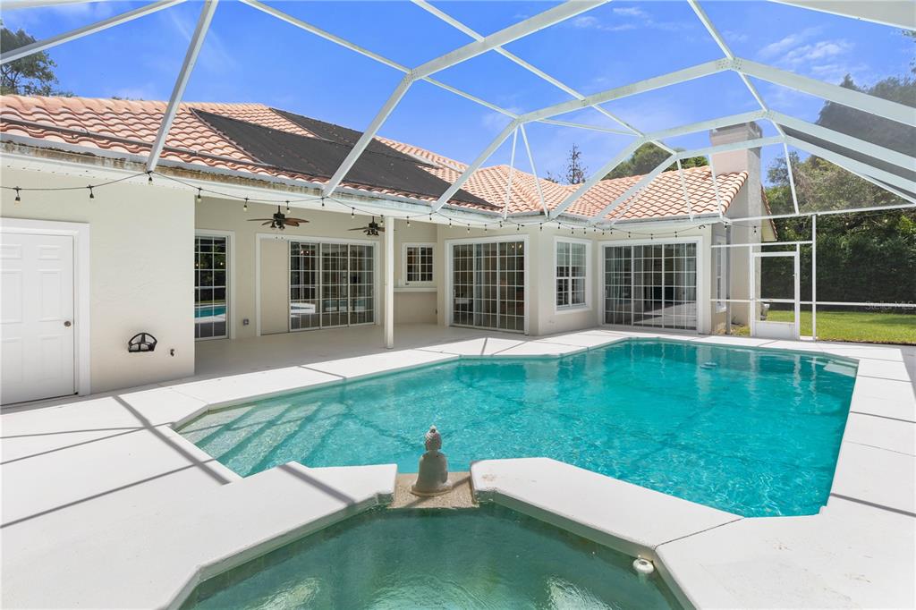 A screened-in patio features a swimming pool, a spa, and multiple sliding glass doors — 9 VIA VERONA, PALM COAST, FL, FL