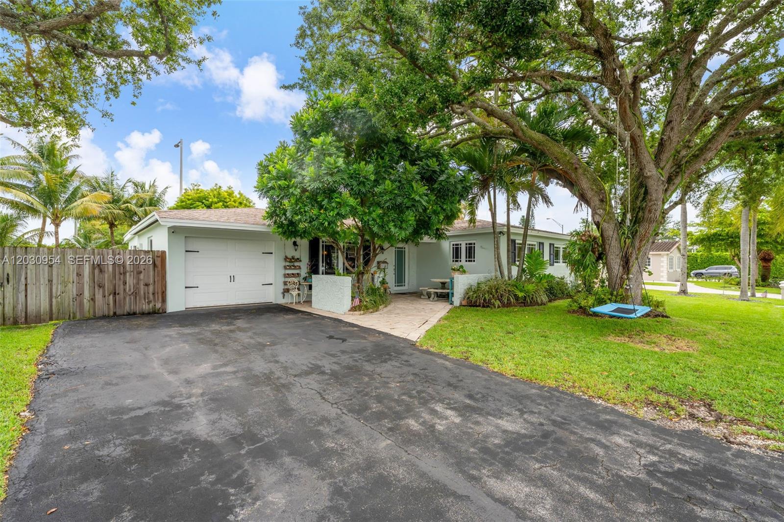 A single-story house with a white garage, a paved driveway, and a large tree — 10421 SW 107th St, Miami FL 33176, MIAMI, FL