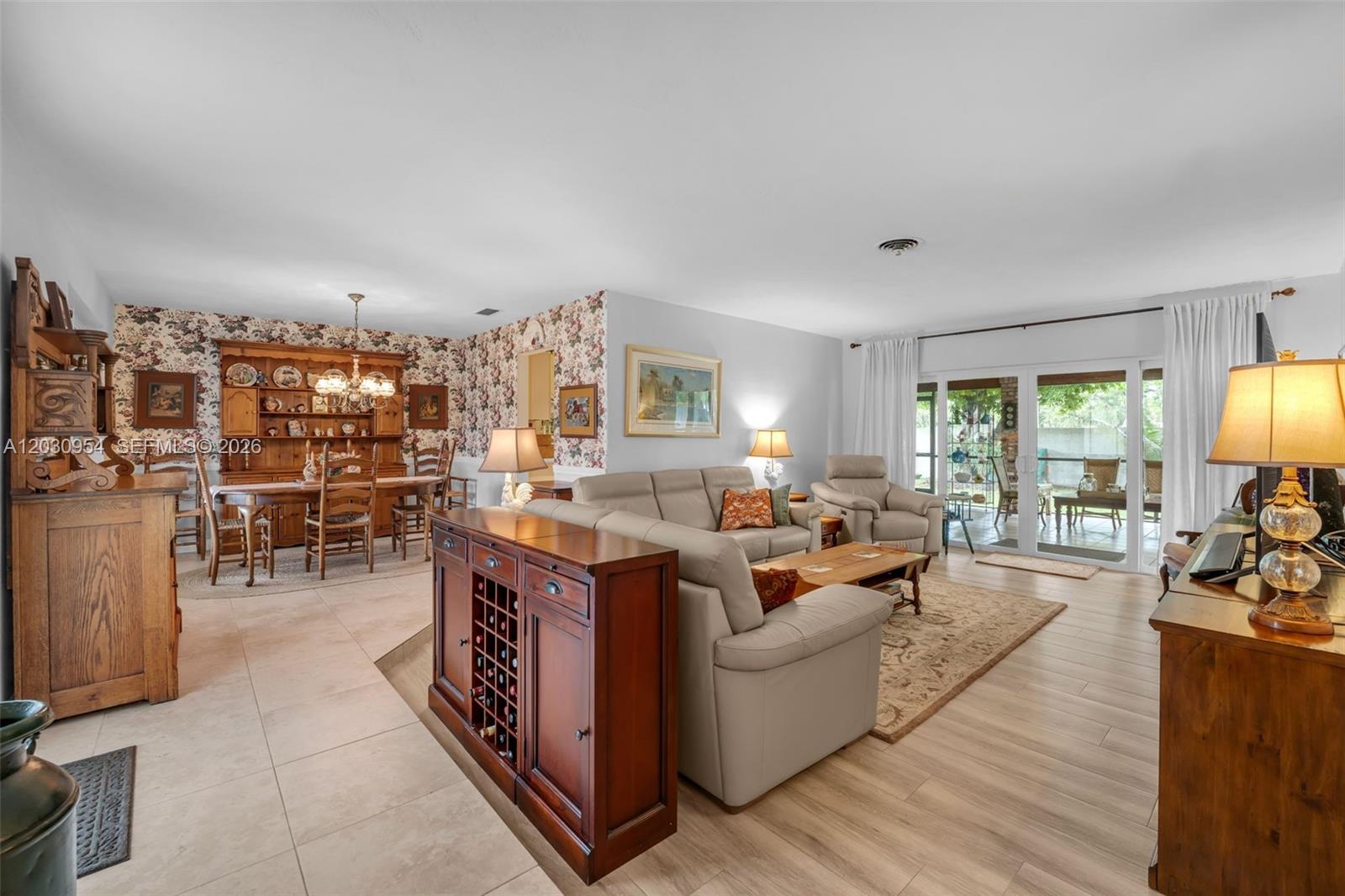 A living and dining room area features tile flooring, floral wallpaper, and a wooden hutch — 10421 SW 107th St, Miami FL 33176, MIAMI, FL