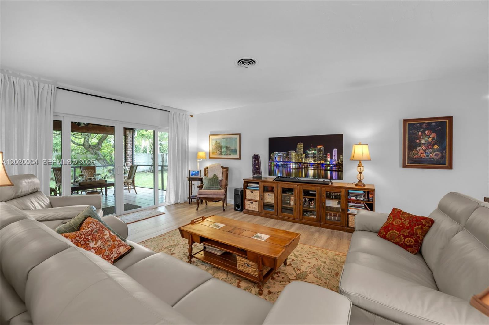 A living room features light gray leather sofas, a wooden coffee table, and a media console — 10421 SW 107th St, Miami FL 33176, MIAMI, FL
