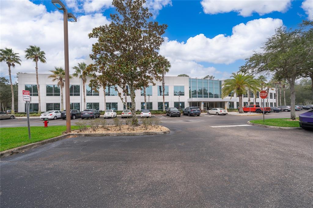 A two-story office building with a parking lot and palm trees under a blue sky — 7560 RED BUG LAKE RD UNIT 2014, OVIEDO, FL