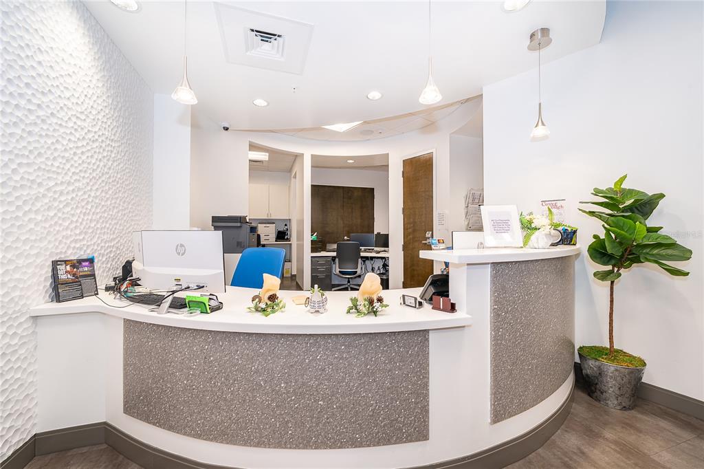 A reception desk with a textured gray front sits in an office with white walls — 7560 RED BUG LAKE RD UNIT 2014, OVIEDO, FL