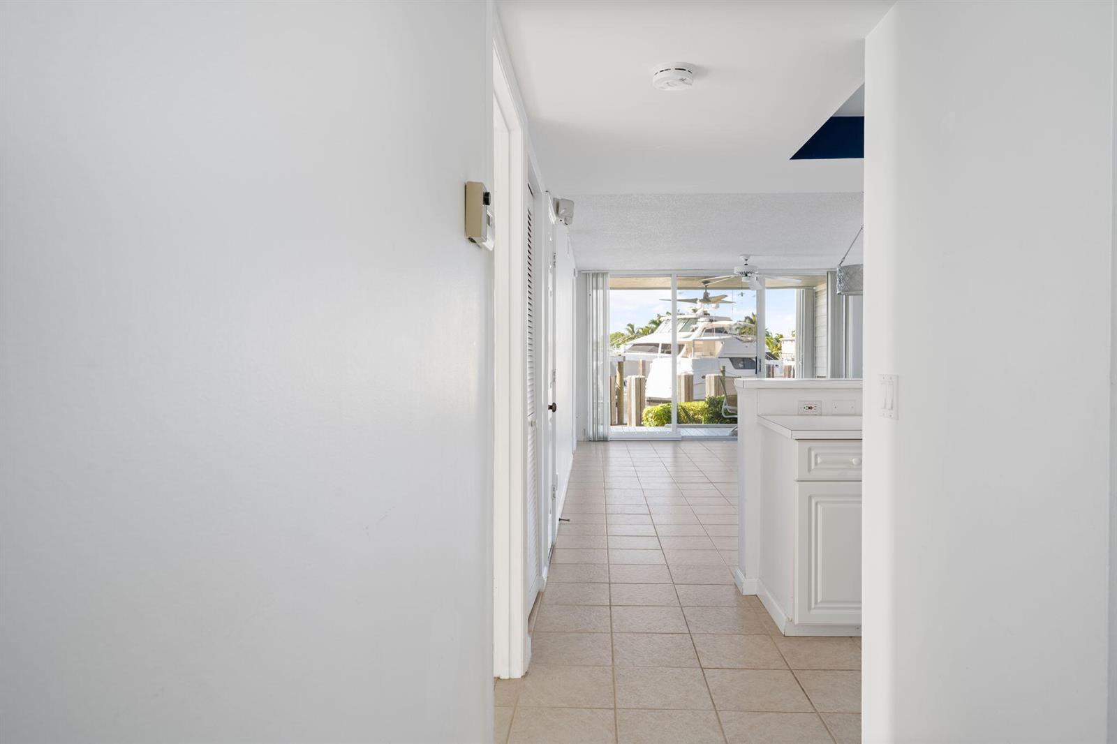 A view through a hallway toward a living area with tile floors and a boat — VERO BEACH, FL