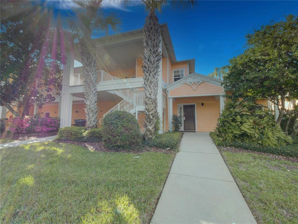 A two-story peach-colored building with a concrete walkway leading to the front entrance — 204 NEW PROVIDENCE UNIT 10104, DAVENPORT, FL