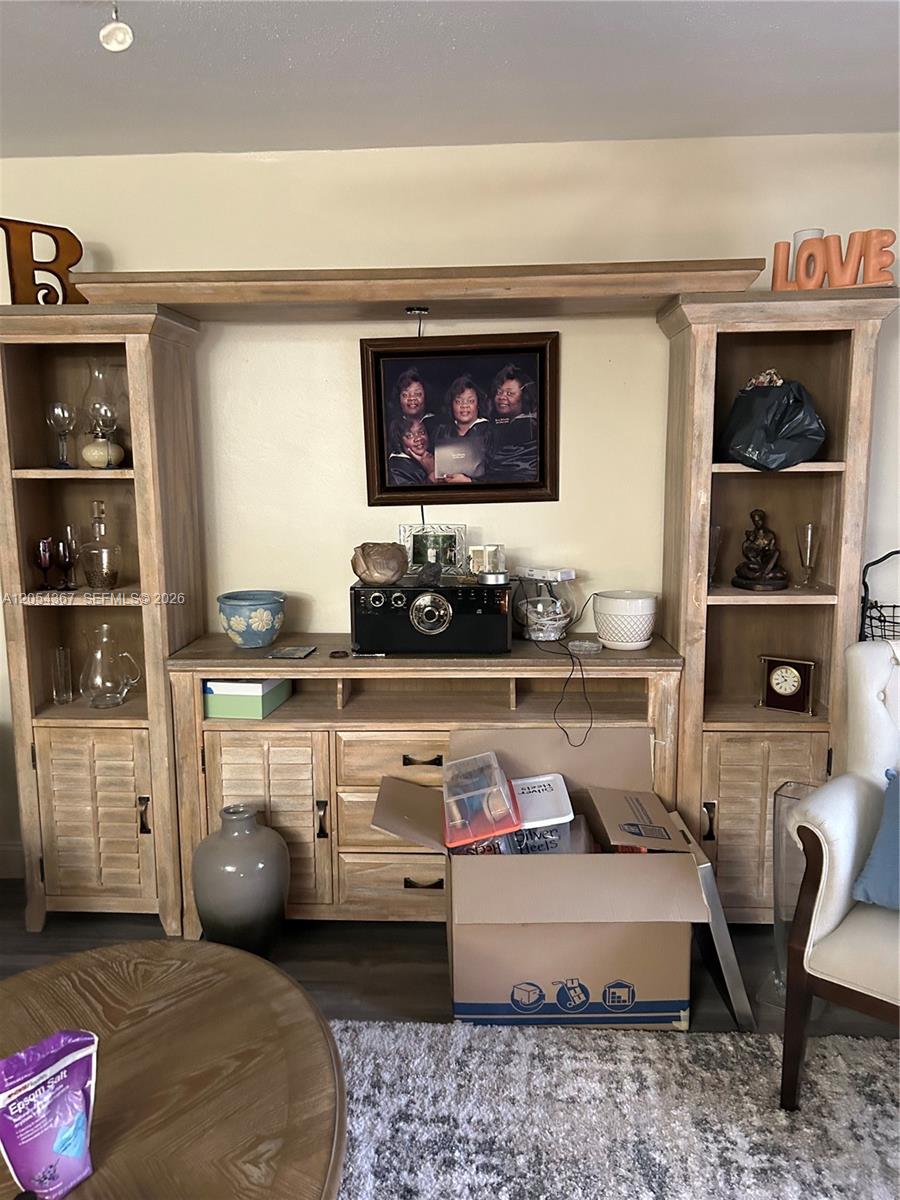 A living room features a large wooden entertainment center with shelving and a central television — 17050 NE 14th Ave # 110, Miami FL 33162, MIAMI, FL