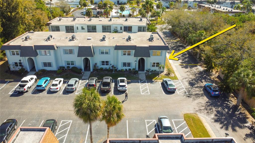 An aerial view shows a multi-story apartment building with a parking lot in front — 215 S MCMULLEN BOOTH ROAD UNIT 182, CLEARWATER, FL