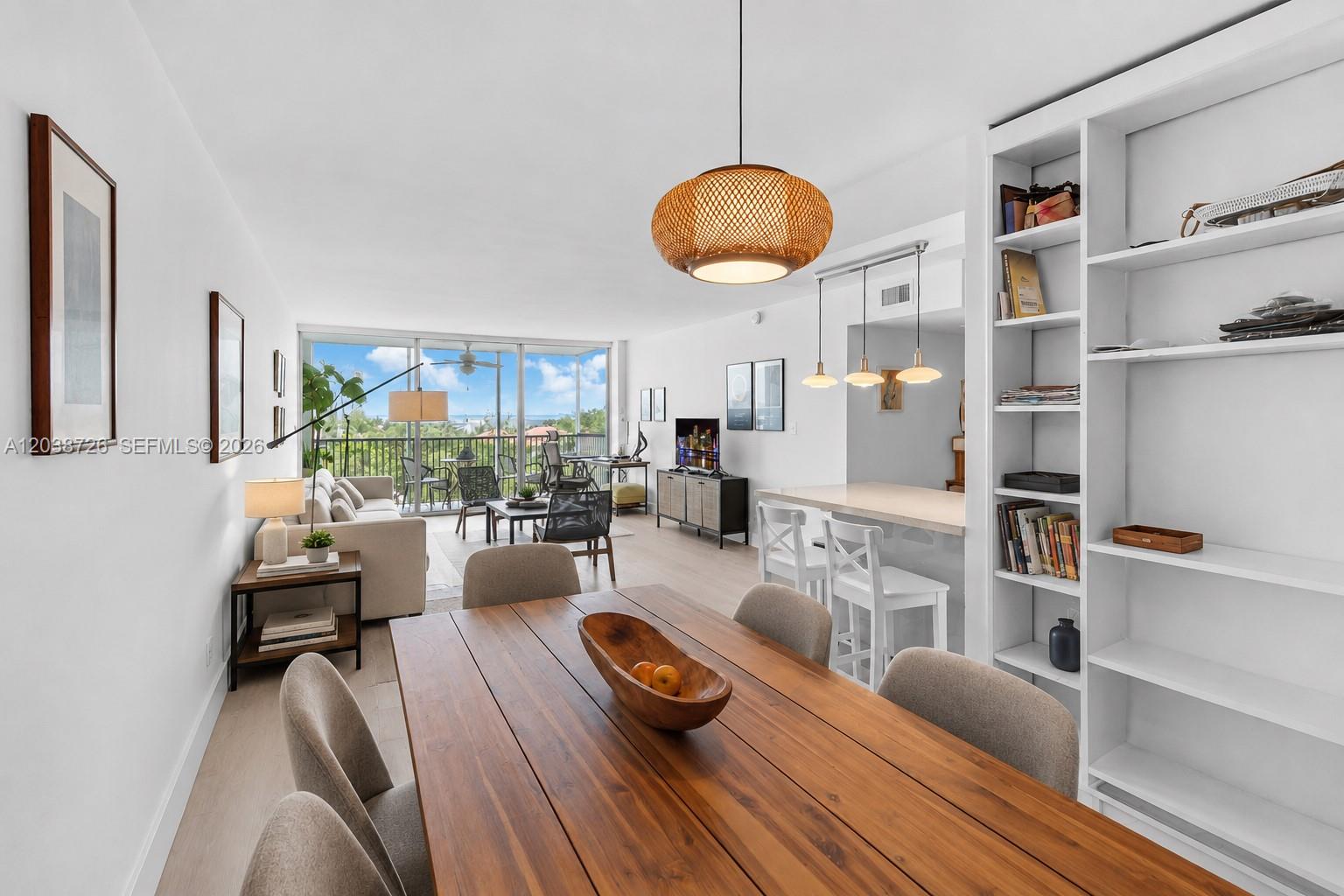 A dining area opens into a living room with a balcony overlooking the water — 150 Ocean Lane Dr # 7C, Key Biscayne FL 33149, KEY BISCAYNE, FL