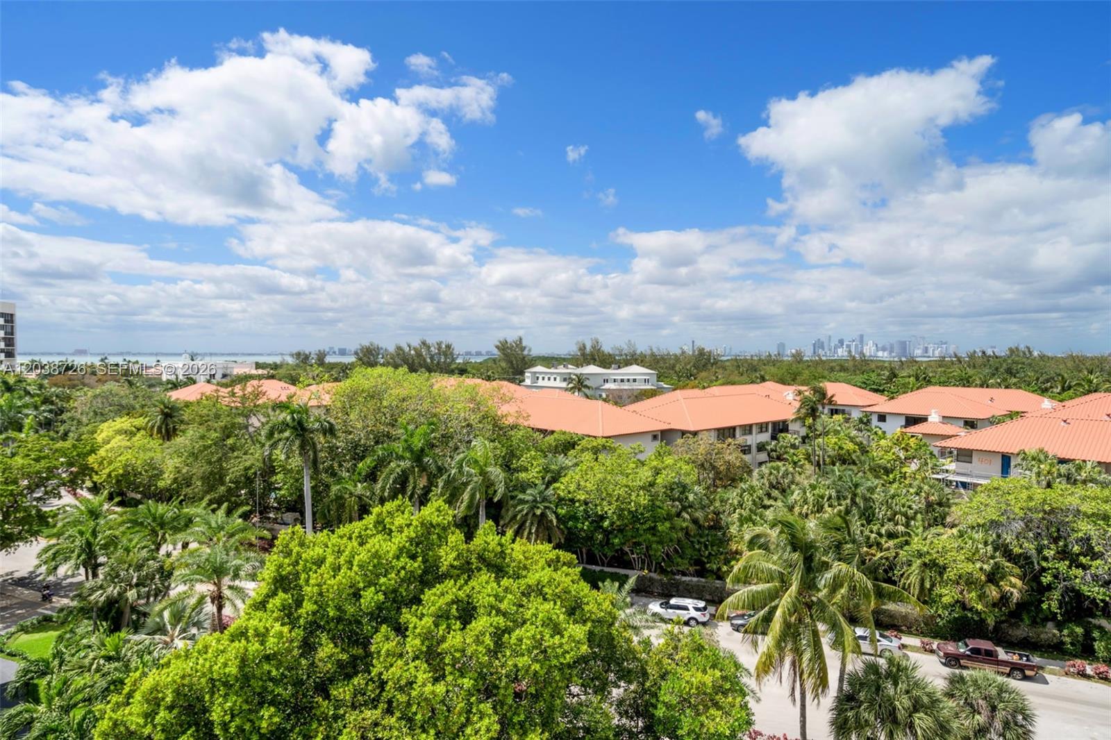 An elevated view shows residential buildings with orange tile roofs surrounded by lush green trees — 150 Ocean Lane Dr # 7C, Key Biscayne FL 33149, KEY BISCAYNE, FL