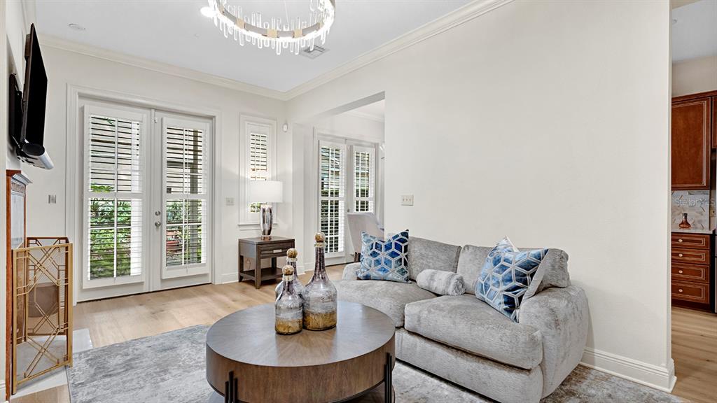 A living room features a gray sofa, a round coffee table, and French doors — 1223 COUNTRY CLUB OAKS CIRCLE, ORLANDO, FL