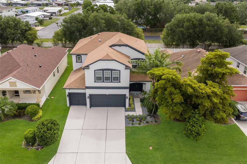 An aerial view of a two-story house with a tan roof and a concrete driveway — 5815 ARBOR WOOD COURT, BRADENTON, FL