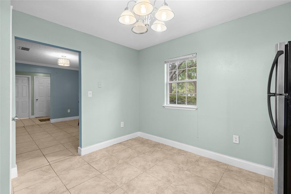 A dining area with light green walls, tile flooring, a chandelier, and a window — 3116 CLUBSIDE DRIVE, LONGWOOD, FL