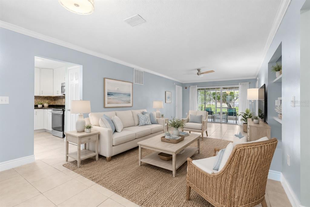 A bright living room features light blue walls, tile flooring, a sofa, and patio doors — 3116 CLUBSIDE DRIVE, LONGWOOD, FL