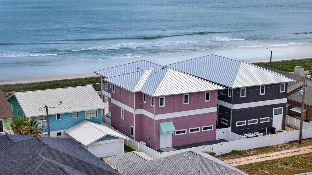 An aerial view shows a pink house and a dark gray house near the beach — 2112 S OCEAN SHORE BOULEVARD, FLAGLER BEACH, FL