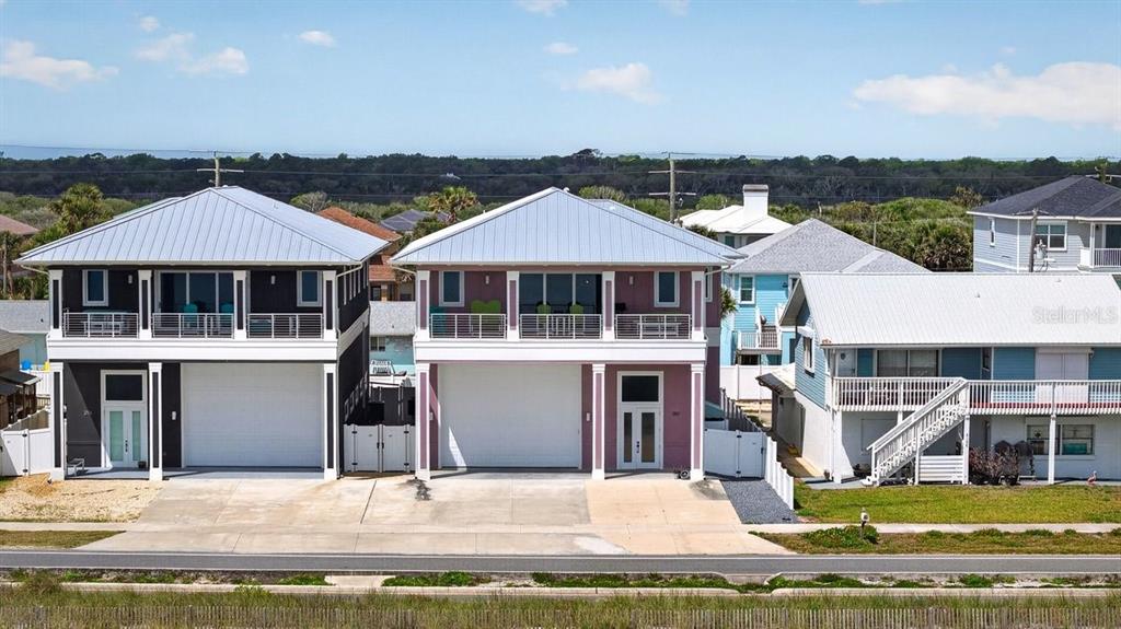 An exterior view of three multi-story coastal houses with metal roofs and elevated balconies — 2112 S OCEAN SHORE BOULEVARD, FLAGLER BEACH, FL