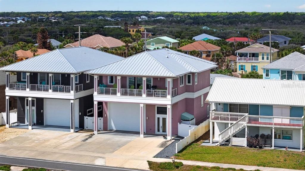 An aerial view shows three multi-story coastal homes with metal roofs and elevated balconies — 2112 S OCEAN SHORE BOULEVARD, FLAGLER BEACH, FL