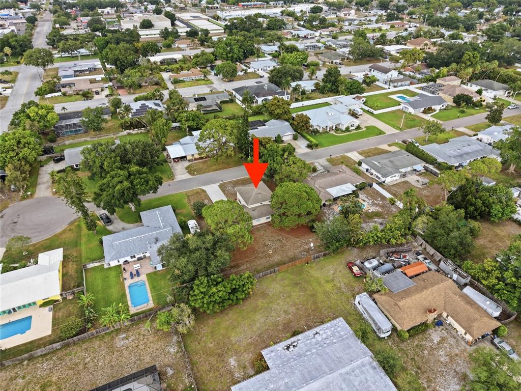 An aerial view shows a single-story house with a red arrow pointing to its roof — 5315 9TH AVENUE DRIVE W, BRADENTON, FL