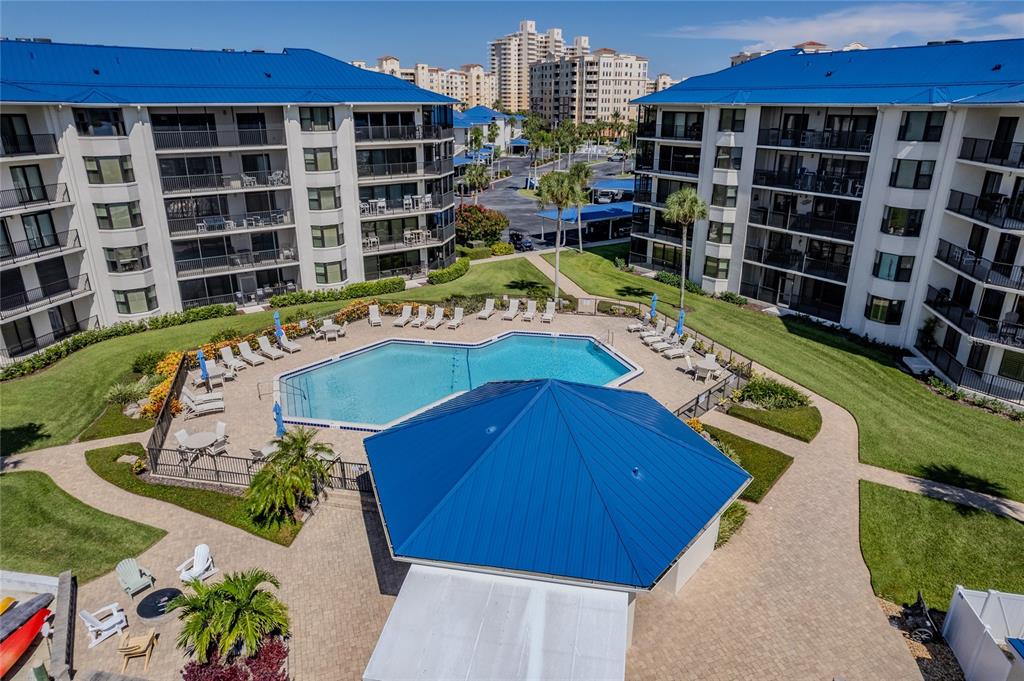 An aerial view shows a swimming pool and a blue-roofed pavilion between two apartment buildings — 2700 N PENINSULA AVENUE UNIT 516, NEW SMYRNA BEACH, FL