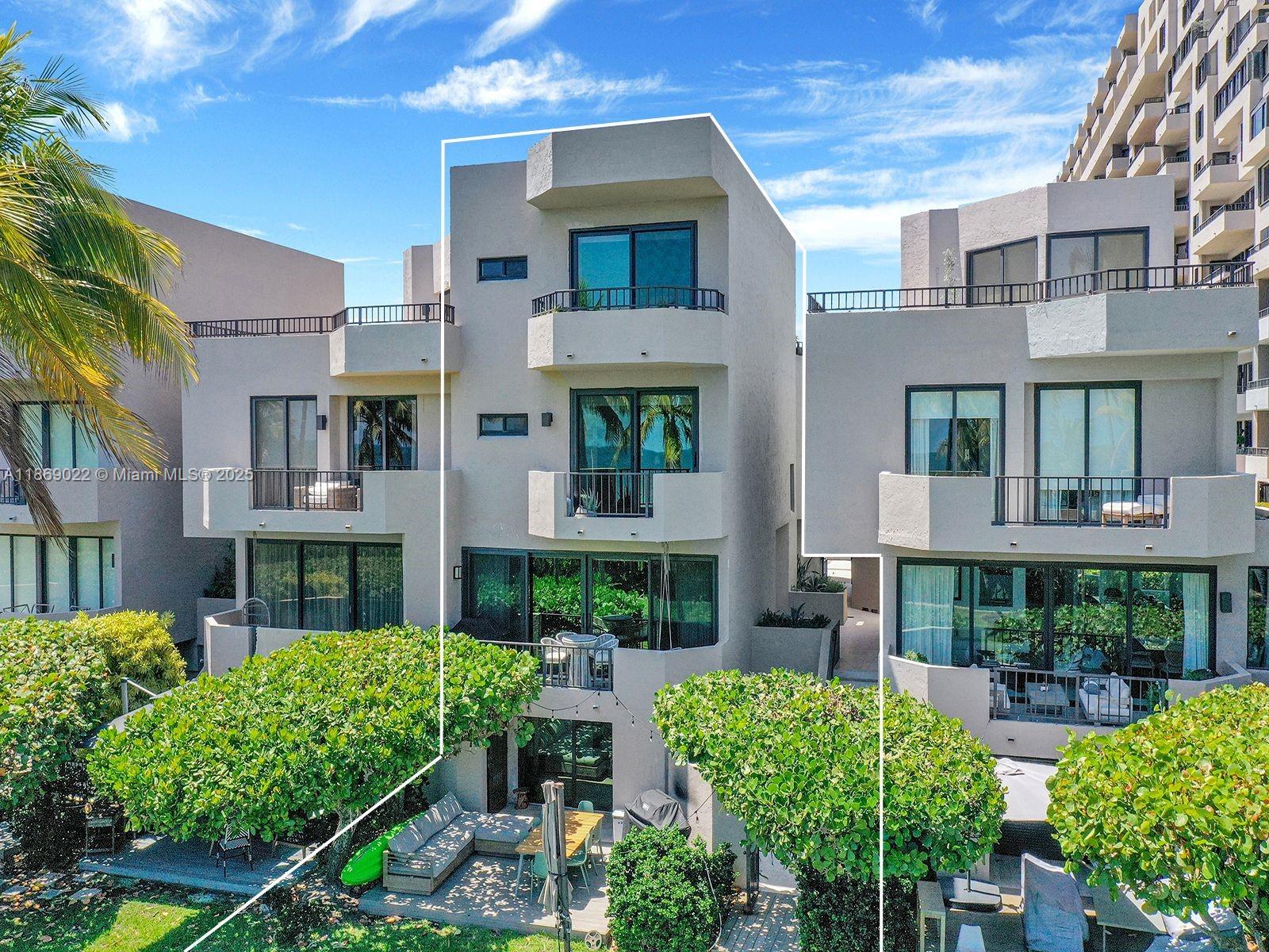 An exterior view of a multi-story residential building with balconies and a ground-level patio — 201 Crandon Blvd # 176, Key Biscayne FL 33149, KEY BISCAYNE, FL