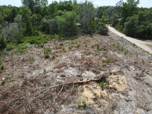 An aerial view of a cleared, sandy residential lot bordered by trees and a road — Y SE 143RD LN, UMATILLA, FL
