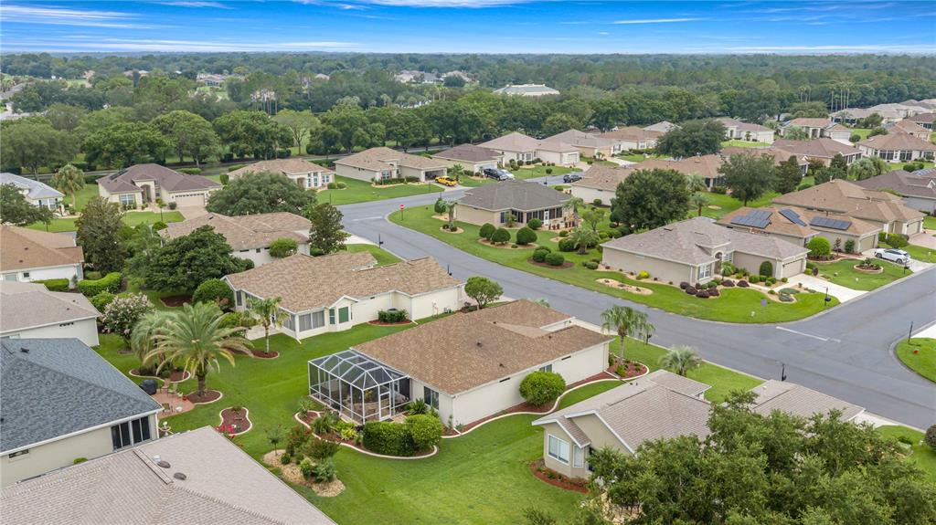 An aerial view of a suburban neighborhood featuring single-story homes with lawns and paved streets — 12503 SE 94TH COURT, SUMMERFIELD, FL