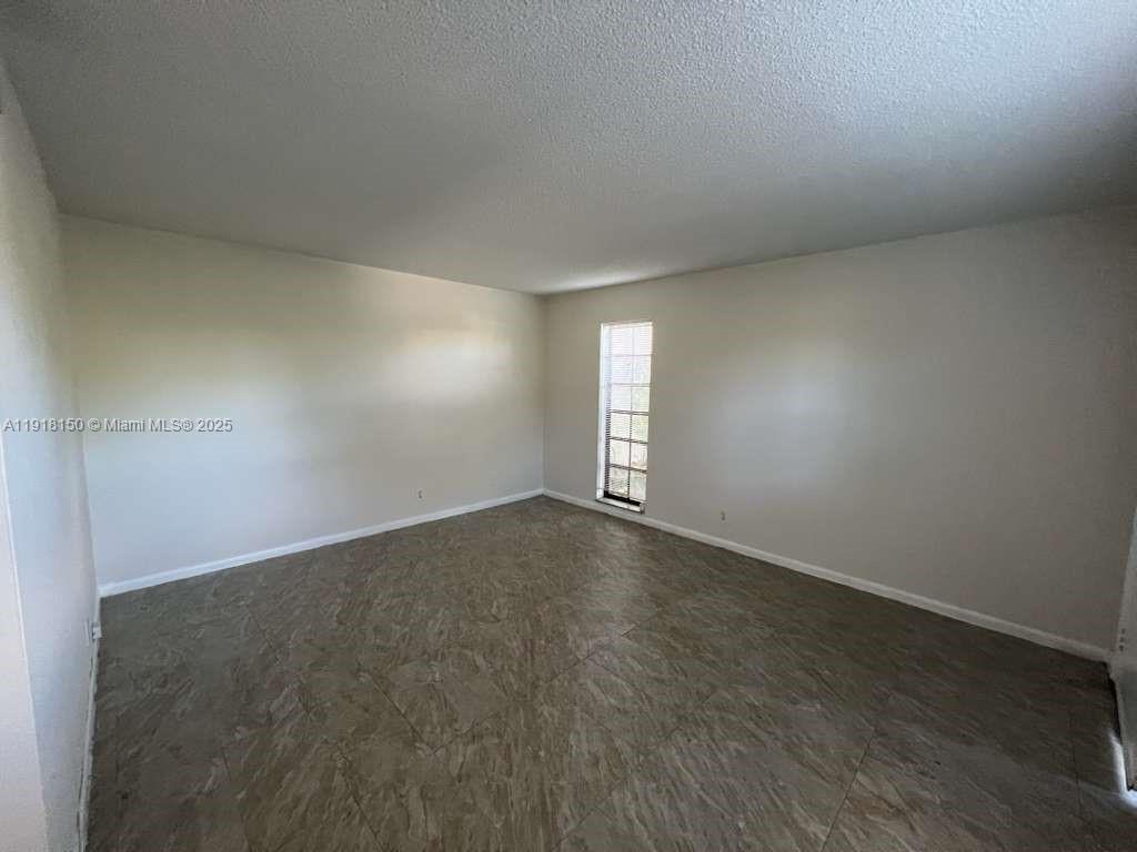 An empty room features light-colored walls, a single window, and patterned tile flooring — 721 SE 1st Way # B18, Deerfield Beach FL 33441, DEERFIELD BEACH, FL