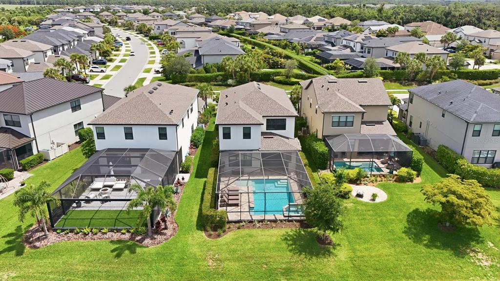 An aerial view shows three suburban houses with screened-in pools and backyards — 8212 SHOOTING STAR RD, SARASOTA, FL