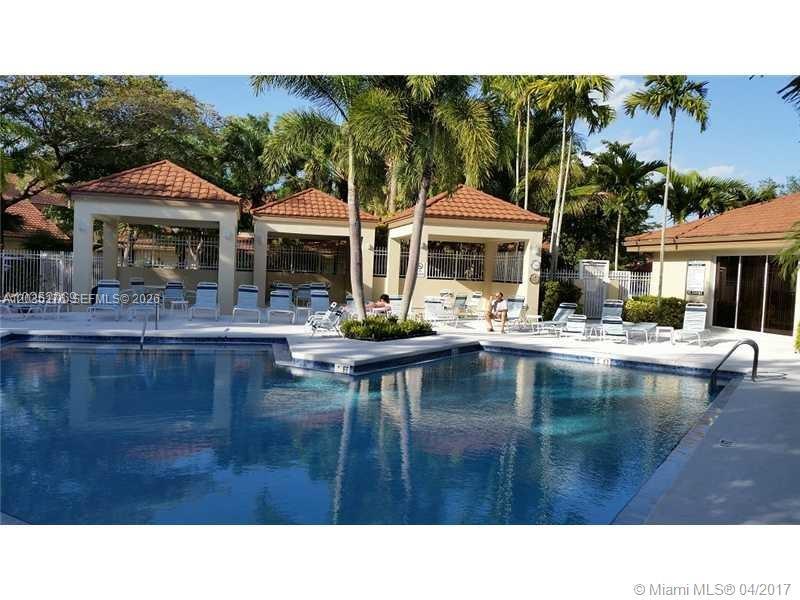 A swimming pool is surrounded by a patio with several gazebos and lounge chairs — PLANTATION, FL