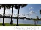 A view of a lake with palm trees in the foreground and a fountain — PLANTATION, FL