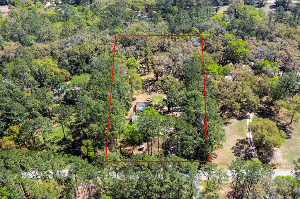An aerial view shows a wooded residential lot outlined in red with a house and pool — 7615 NW 176TH STREET, ALACHUA, FL