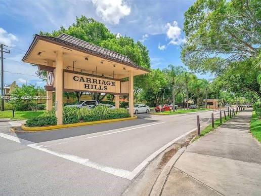 A large, covered entrance sign for Carriage Hills stands over a paved road — 301 Cambridge Rd # 306, Hollywood FL 33024, HOLLYWOOD, FL