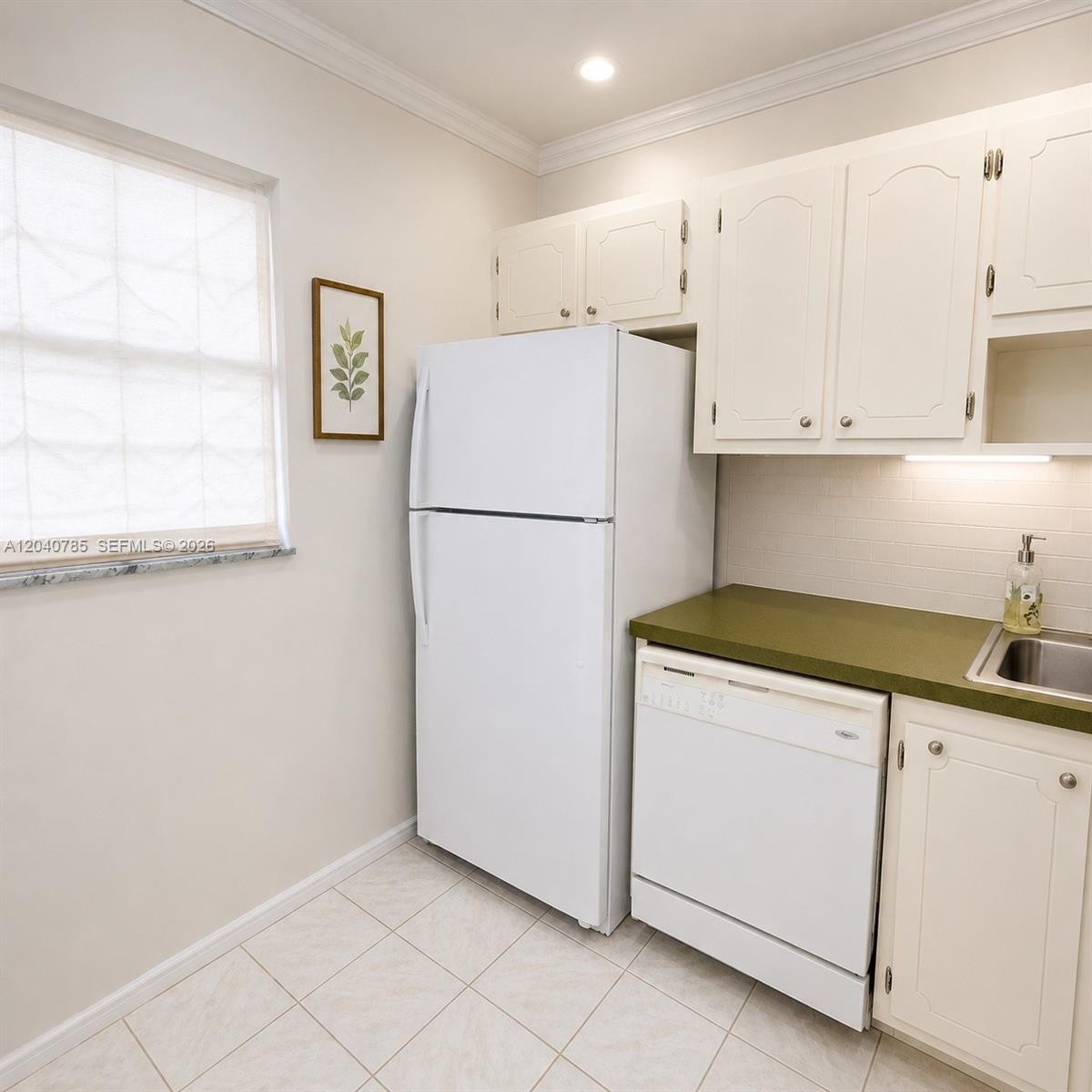 A kitchen features white cabinets, a white refrigerator, a dishwasher, and a green countertop — 301 Cambridge Rd # 306, Hollywood FL 33024, HOLLYWOOD, FL