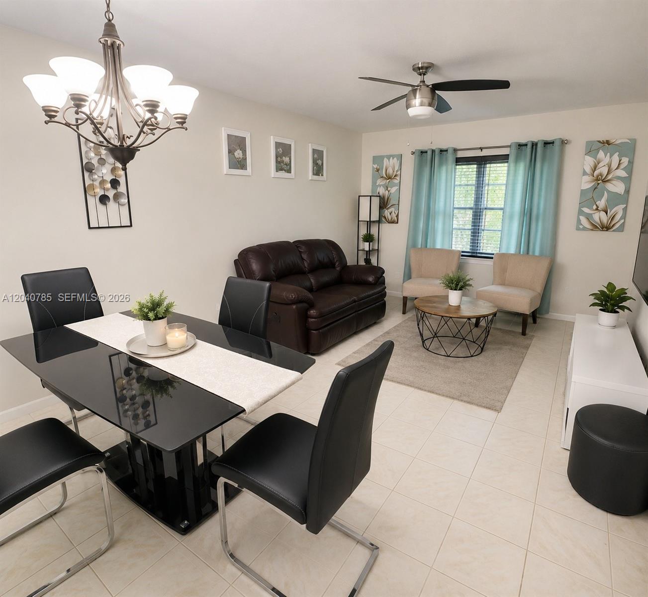 A dining area with a black table and chairs flows into a living room space — 301 Cambridge Rd # 306, Hollywood FL 33024, HOLLYWOOD, FL