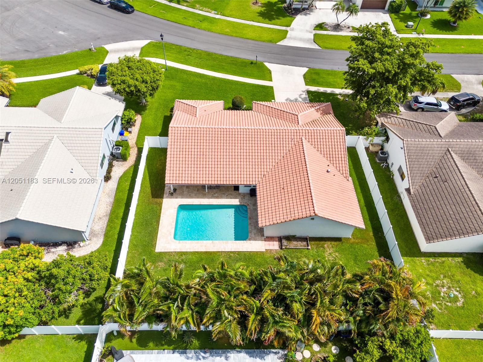 An aerial view shows a house with a tiled roof, a swimming pool, and landscaping — 22433 Ensenada Way, Boca Raton FL 33433, BOCA RATON, FL