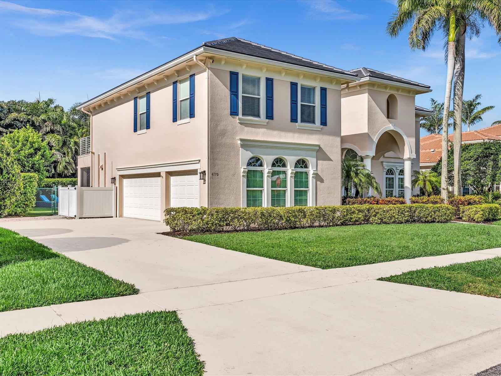 A two-story beige house with blue shutters, a two-car garage, and a manicured front lawn — 4770 Glenn Pine Lane, Boynton Beach FL 33436, BOYNTON BEACH, FL