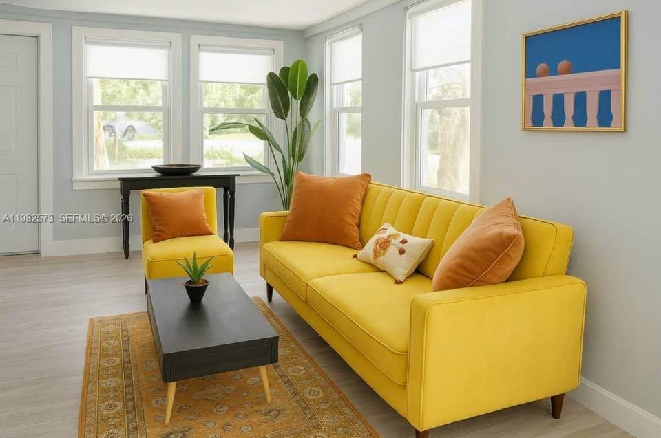 A living room features a yellow sofa, a matching armchair, and a black coffee table — 213 N E St, Lake Worth FL 33460, LAKE WORTH, FL