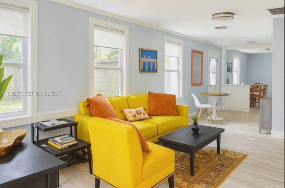 A living room features a yellow sofa and armchair, a black coffee table, and light flooring — 213 N E St, Lake Worth FL 33460, LAKE WORTH, FL