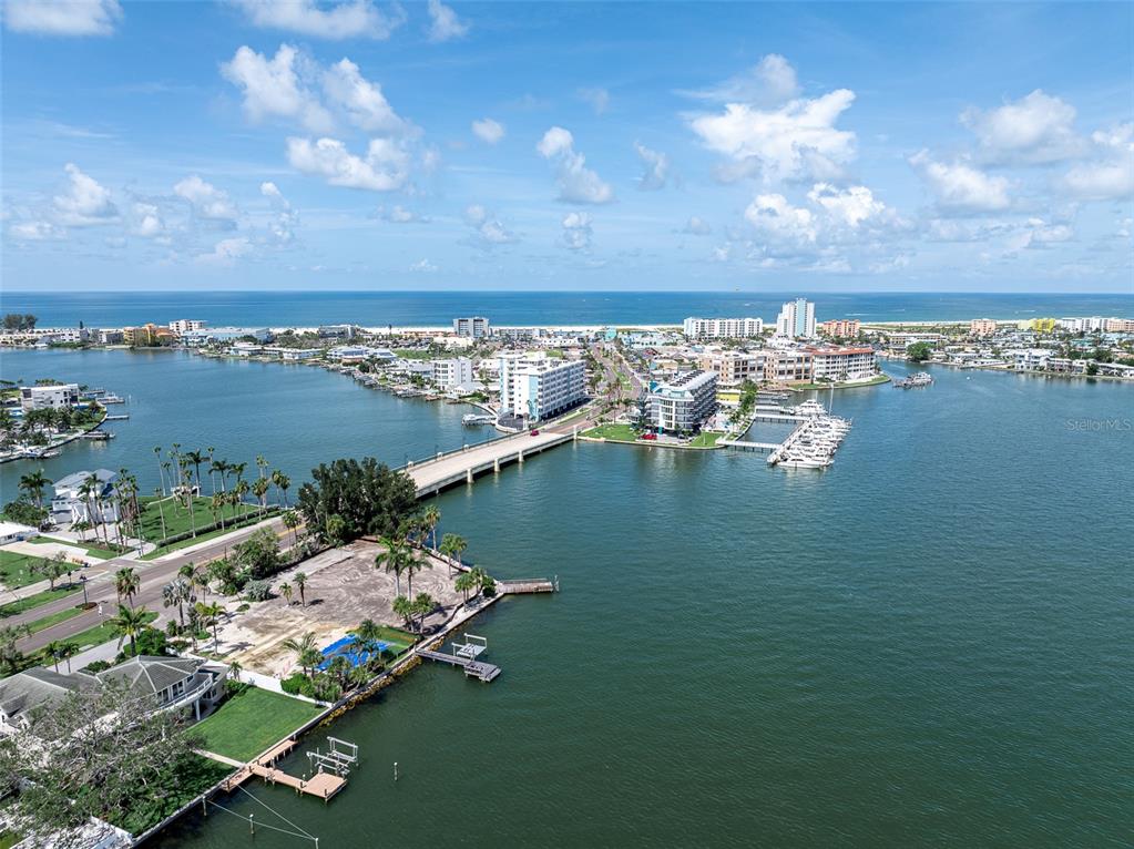 An aerial view shows a bridge connecting a coastal area with boats and buildings — 2 PARADISE LANE, TREASURE ISLAND, FL