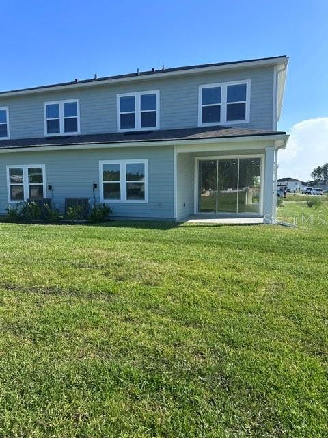 The exterior of a two-story house features light blue siding and a ground-level patio — 121 CAMPHOR LAUREL ROAD, ST AUGUSTINE, FL