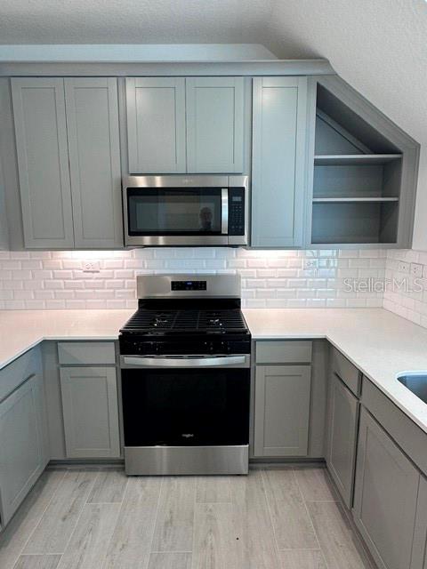 A kitchen features gray cabinets, stainless steel appliances, white quartz countertops, and white subway tile — 121 CAMPHOR LAUREL ROAD, ST AUGUSTINE, FL