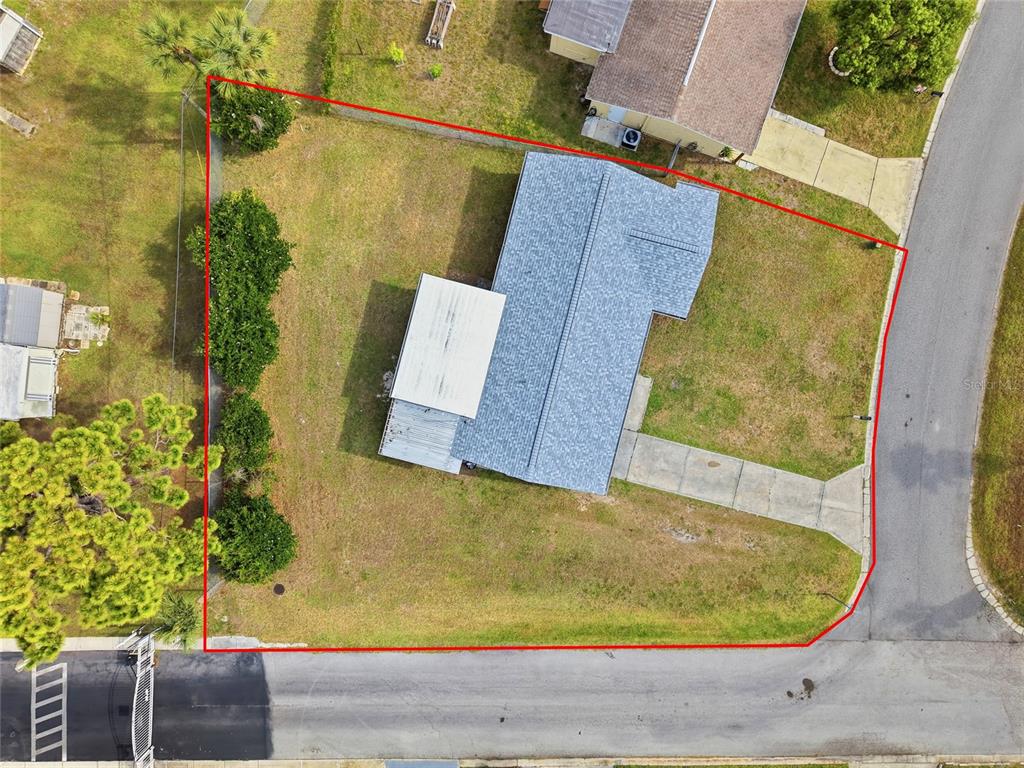 An aerial view shows a single-story house with a driveway on a corner lot — 10737 FILLMORE AVENUE, PORT RICHEY, FL