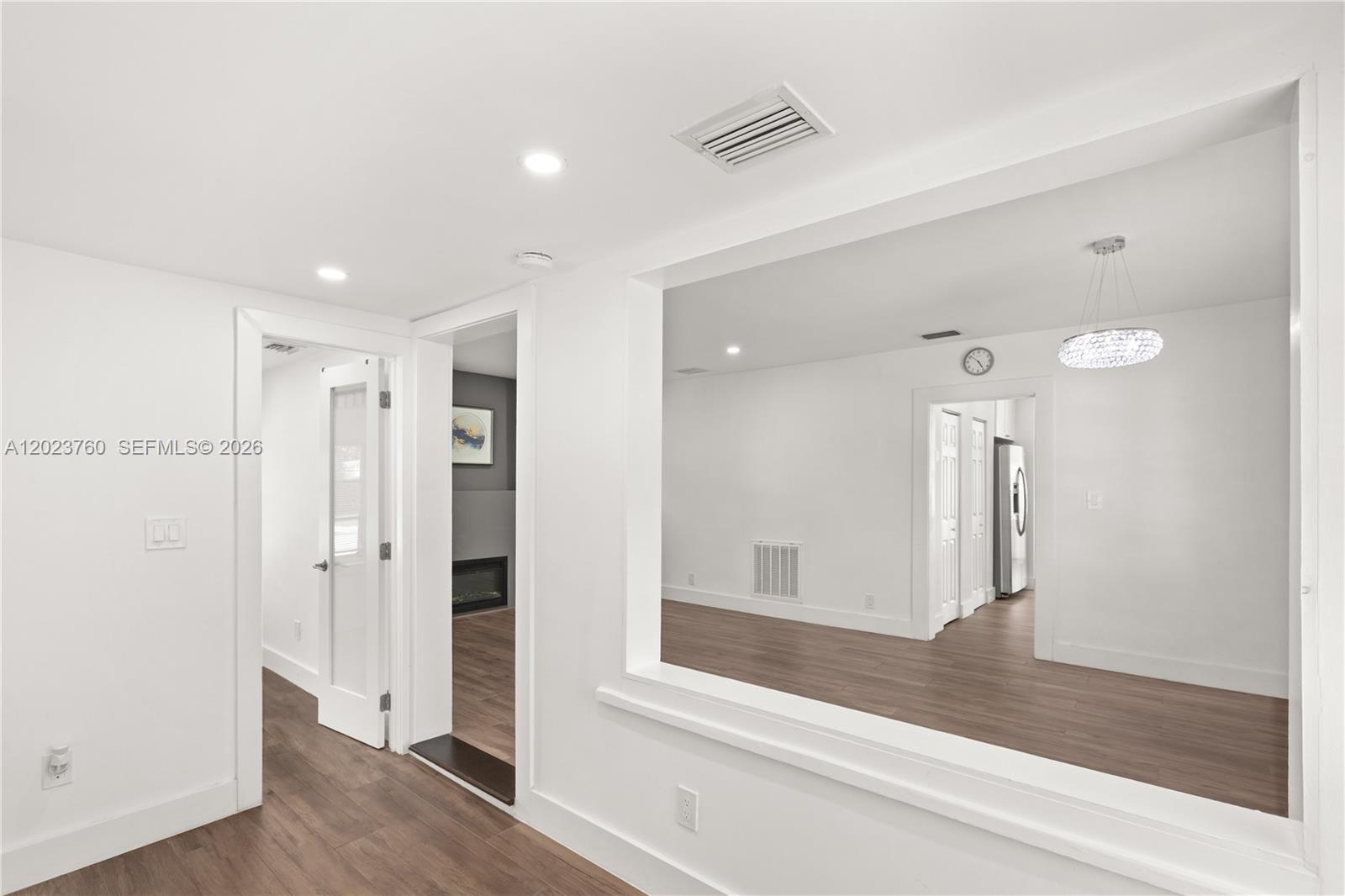 A white room features a large rectangular opening looking into an adjacent living space — 900 Tangier St, Coral Gables FL 33134, CORAL GABLES, FL