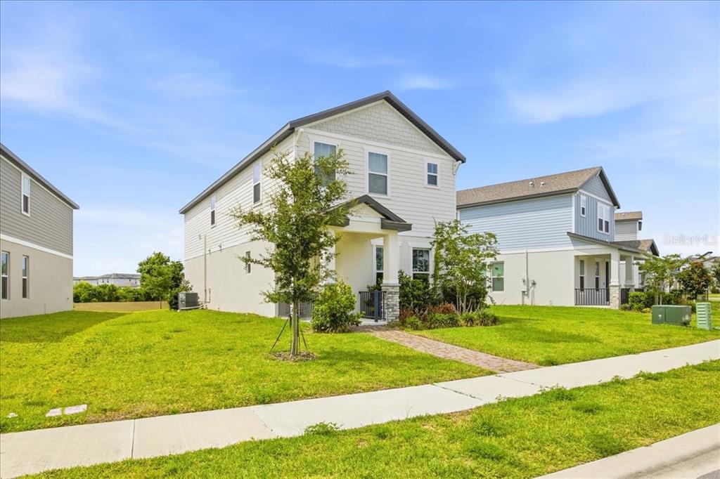 A two-story house with light siding and a small front porch sits on a lawn — 12308 BRACCO STREET, WINTER GARDEN, FL