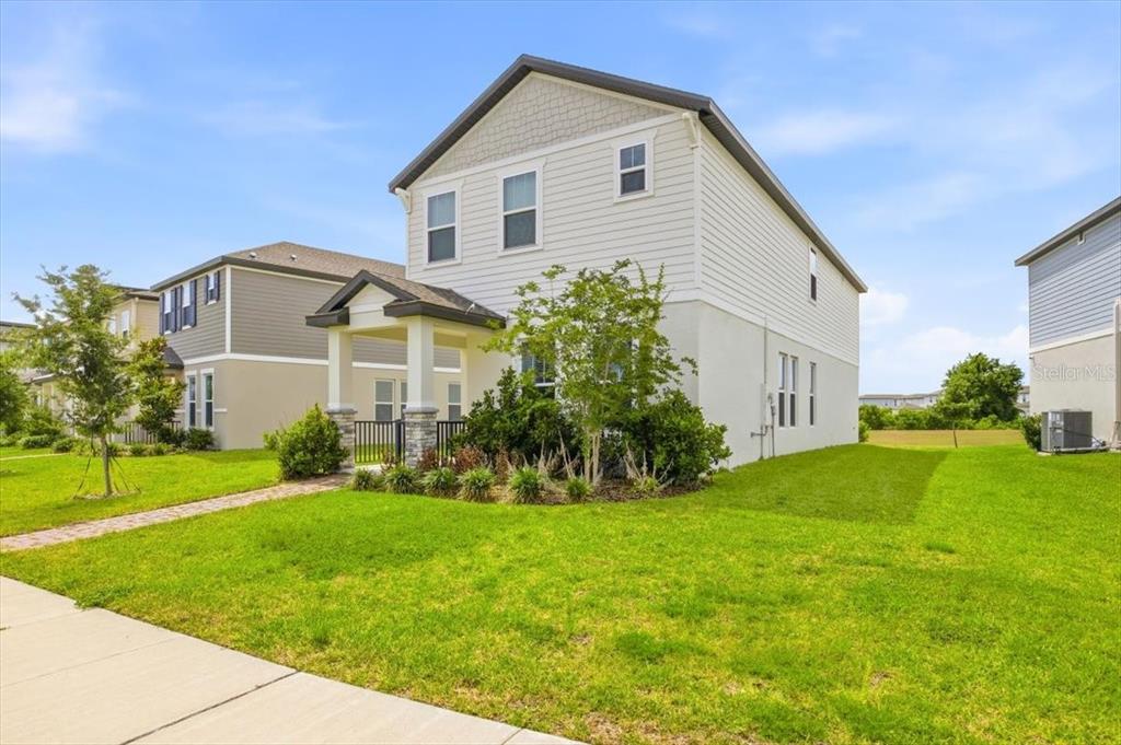 A two-story suburban house with light siding and a small covered front porch — 12308 BRACCO STREET, WINTER GARDEN, FL