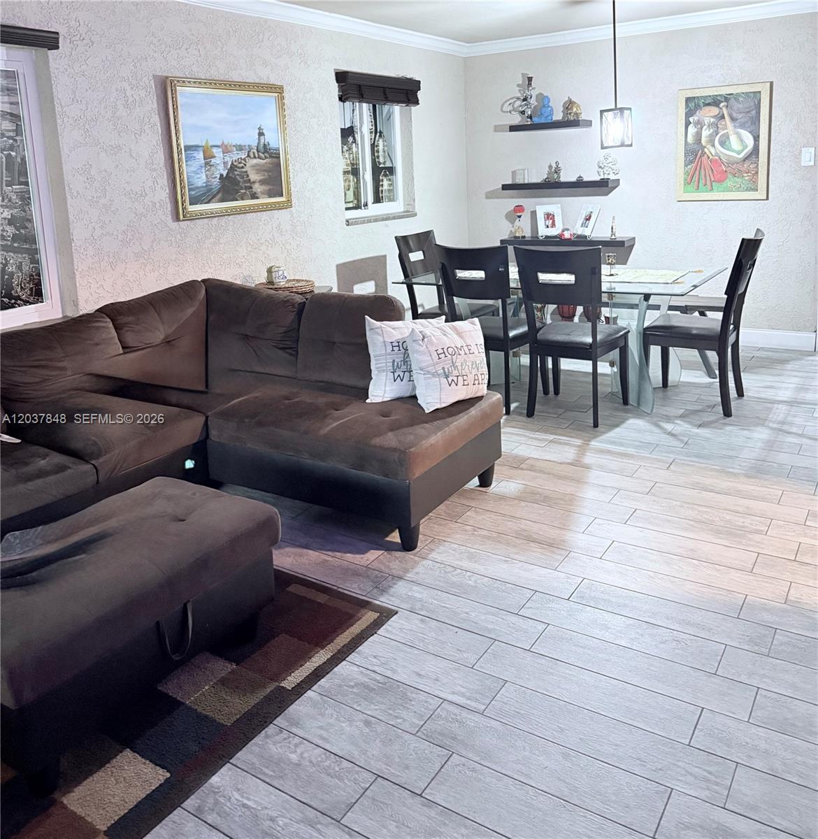 This open-concept living and dining room features a brown sectional sofa and tile flooring — 6424 Meade St, Hollywood FL 33024, HOLLYWOOD, FL