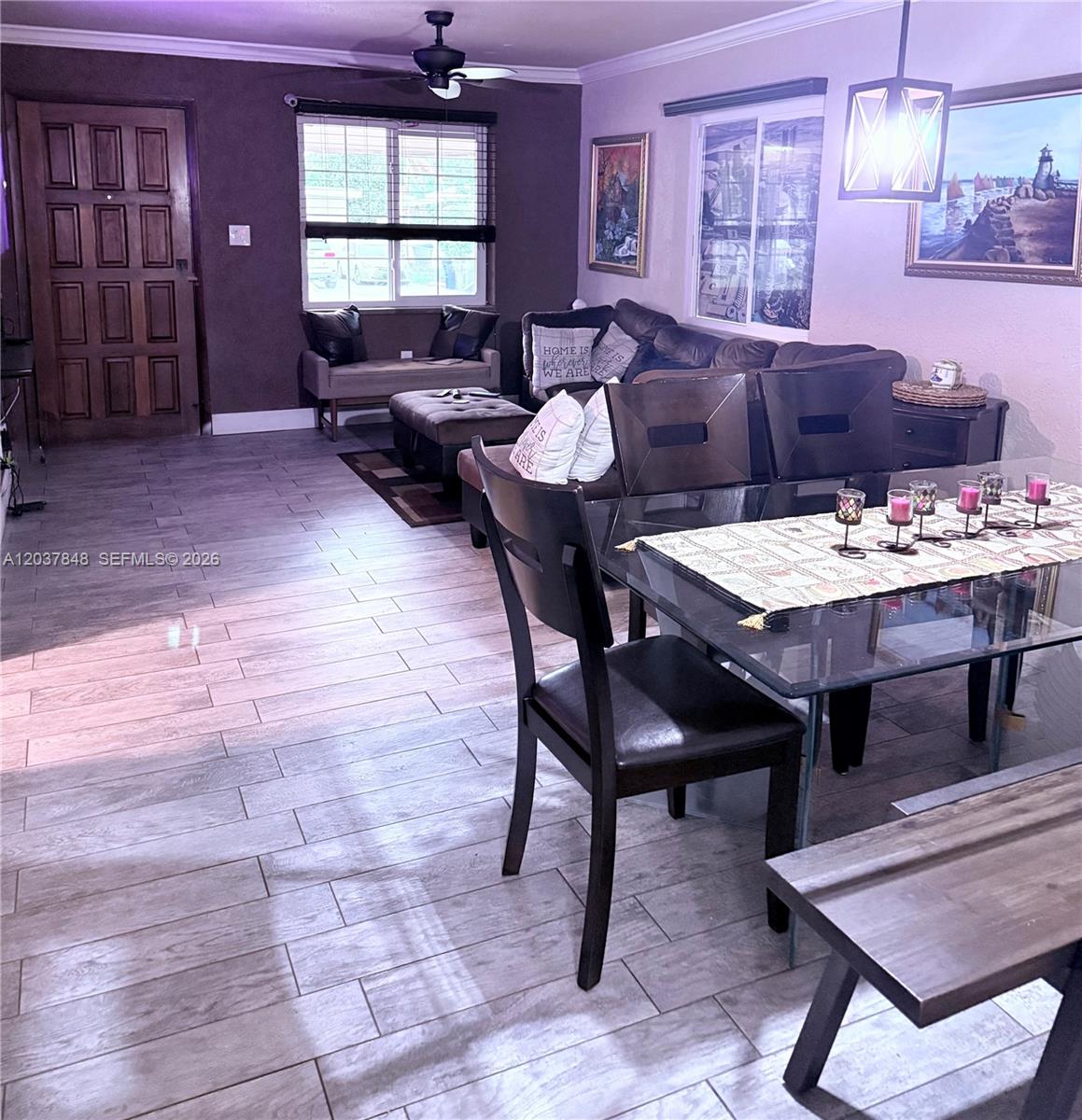 A dining area with a glass table and a living room with dark furniture — 6424 Meade St, Hollywood FL 33024, HOLLYWOOD, FL