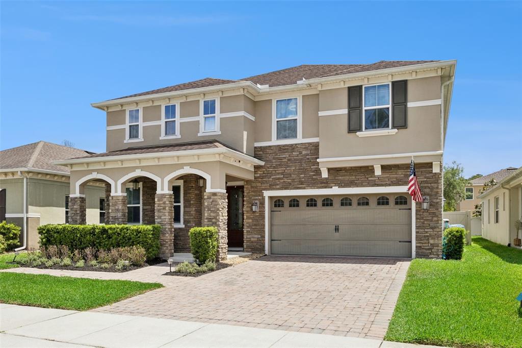 A two-story suburban house features a stone facade, a paved driveway, and a garage — 2331 AVELLINO AVENUE, ST CLOUD, FL