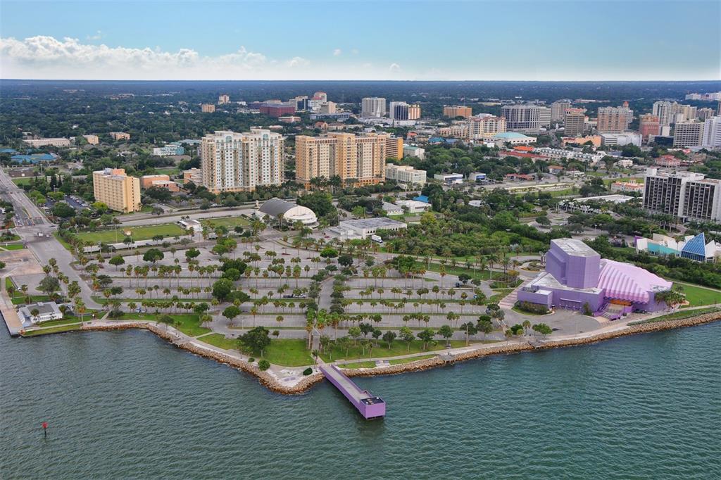 Aerial view of a waterfront parking lot, a purple building, and a city skyline — 750 N TAMIAMI TRAIL UNIT 205, SARASOTA, FL