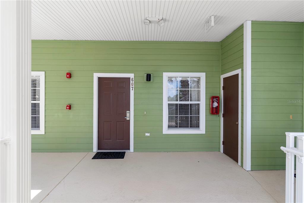 A living and dining area features a glass-top table, gray sofa, and sliding glass doors — 607 GRAN BAHAMA BOULEVARD UNIT B29/U607, DAVENPORT, FL