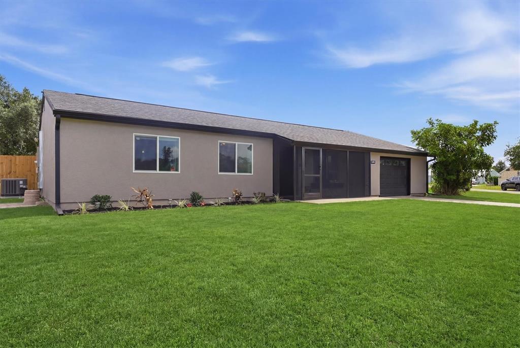 A single-story house with a gray stucco exterior, a screened porch, and a garage — 4681 NEKOOSA STREET, NORTH PORT, FL